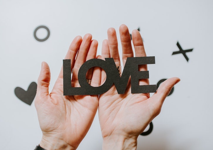 Dłonie trzymające napis LOVE